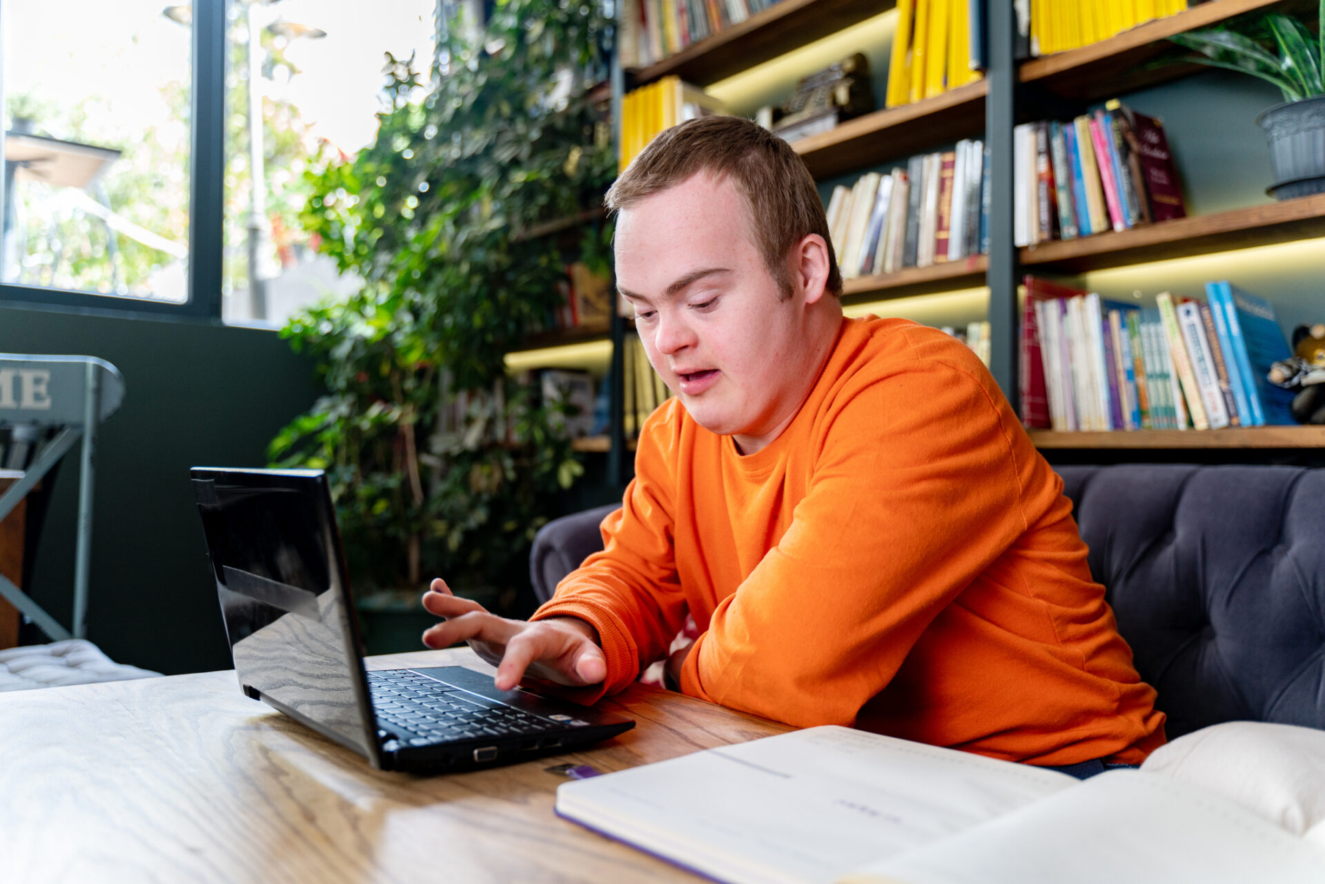 Higher ed professional sitting and working indoors at university, using laptop