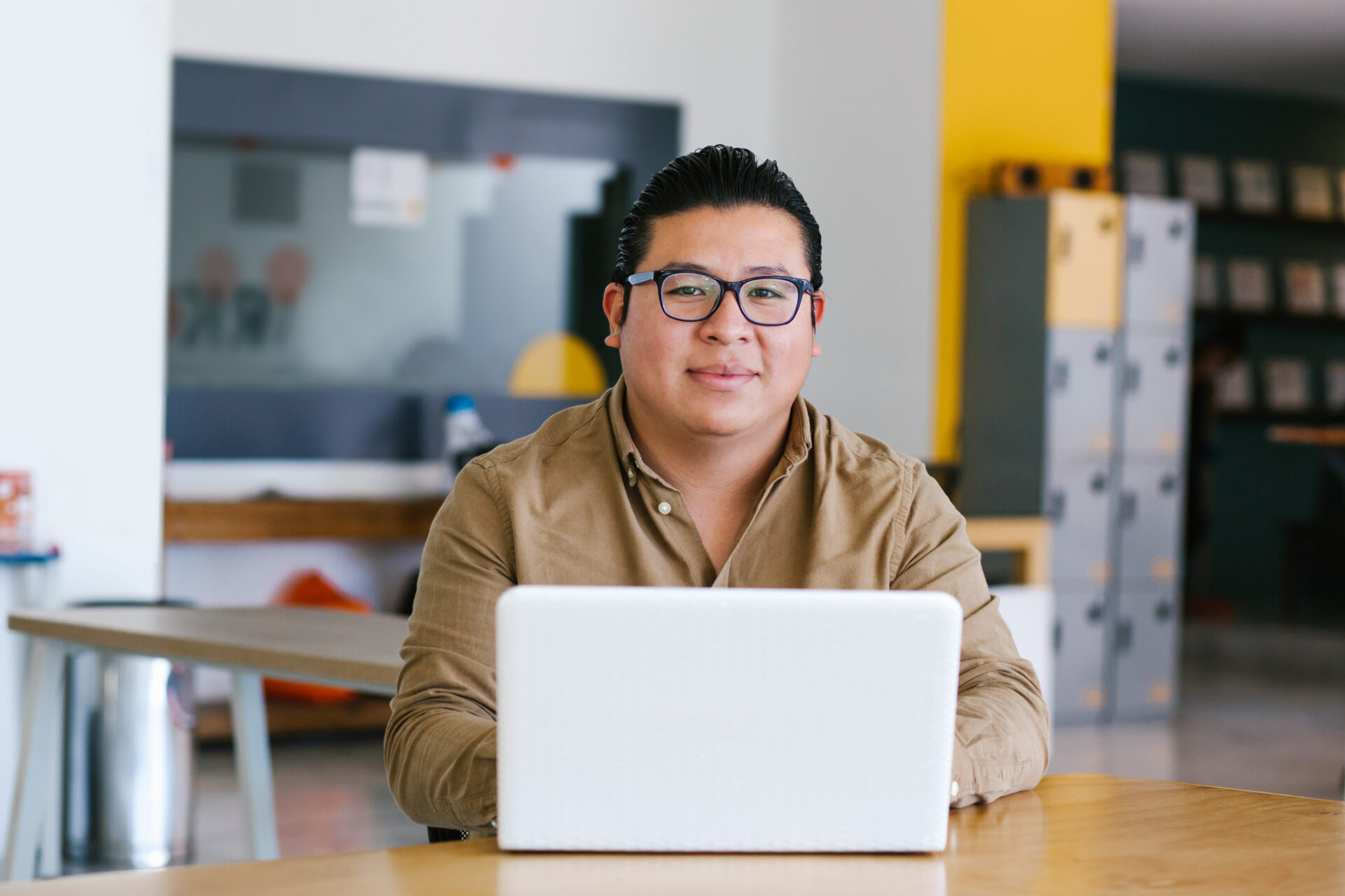 Higher ed professional behind laptop smiling at camera